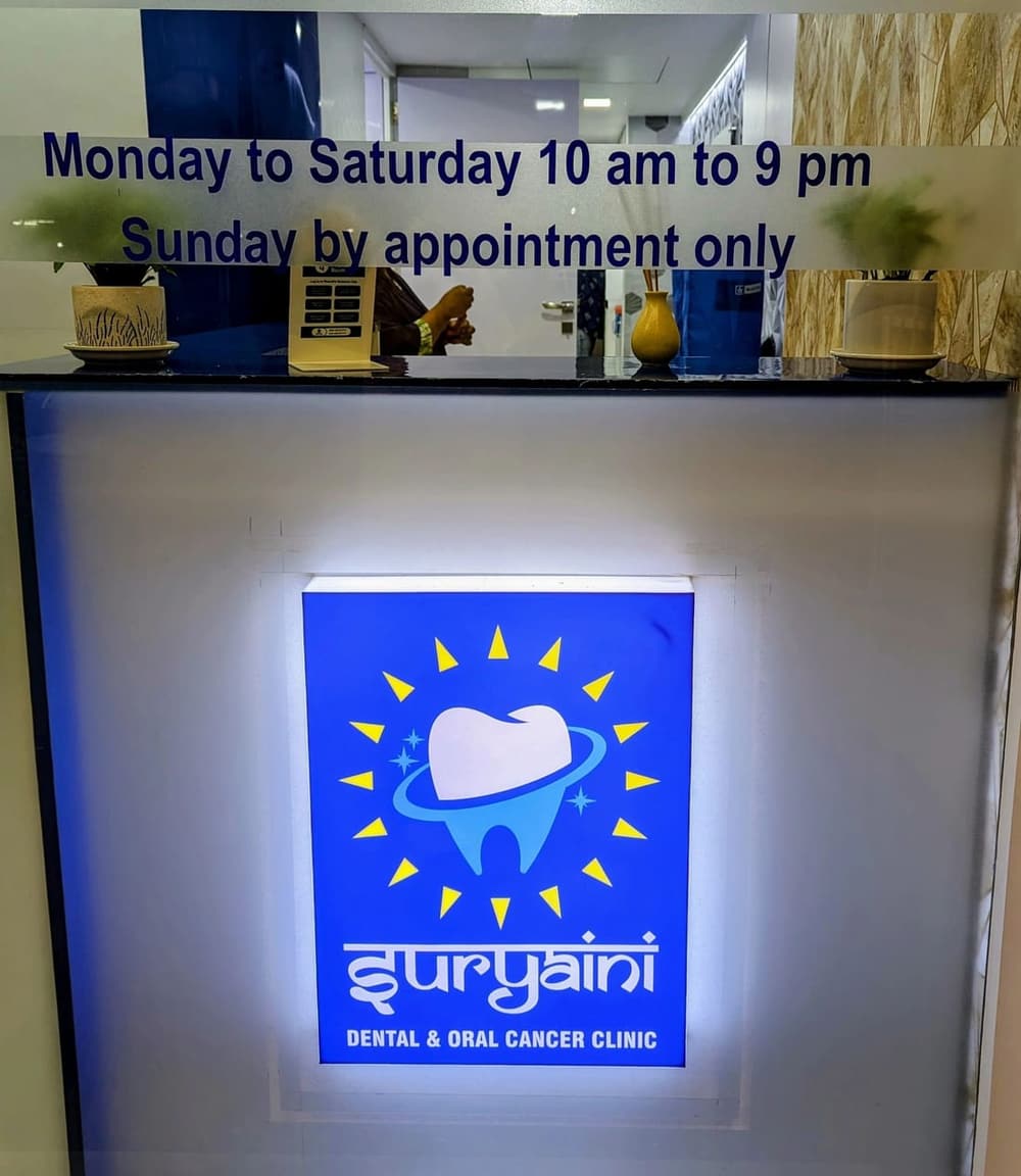 The clinic's lit logo panel at reception, below its hours: Monday to Saturday 10am to 9pm, Sunday by appointment only